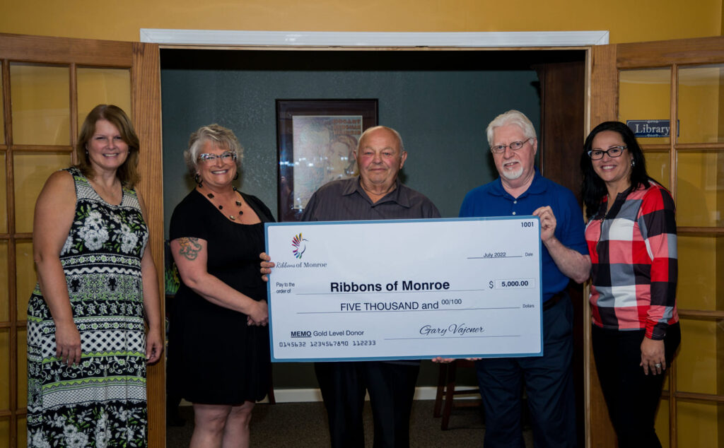 Gary Vajcner presenting a $5,000 Gold Level donation check to the Ribbons of Monroe team in July 2022.